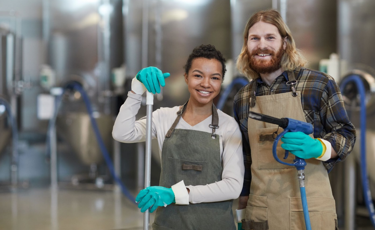 Two commercial cleaning services workers smile on a jobsite.