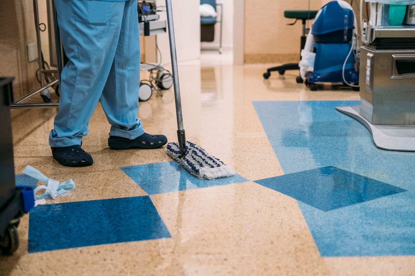 Detail of a cleaning technician in uniform sanitizing a hospital operating room