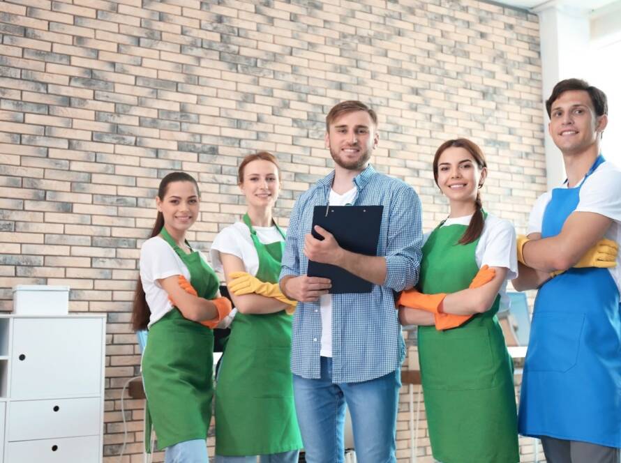 Cleaning staff in uniform posing with a supervisor during a commercial facility walkthrough